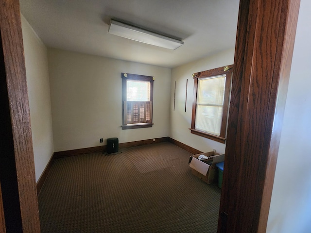 unfurnished room featuring dark carpet