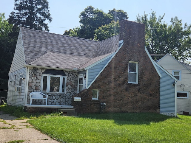 view of front of home featuring cooling unit and a front yard