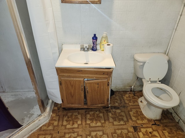 bathroom featuring parquet floors, walk in shower, vanity, tile walls, and toilet