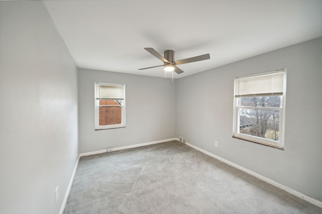 carpeted spare room featuring ceiling fan