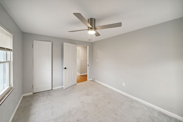 unfurnished bedroom with light colored carpet and ceiling fan