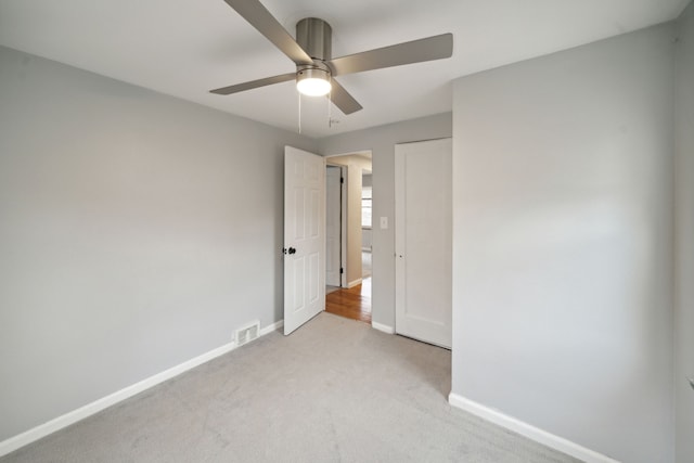 unfurnished bedroom with light carpet and ceiling fan