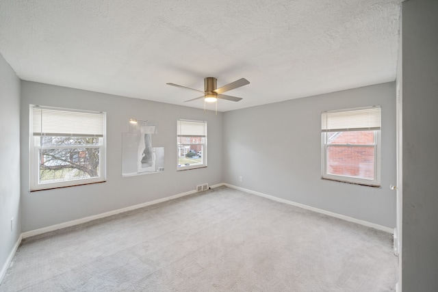 carpeted empty room with a textured ceiling and ceiling fan