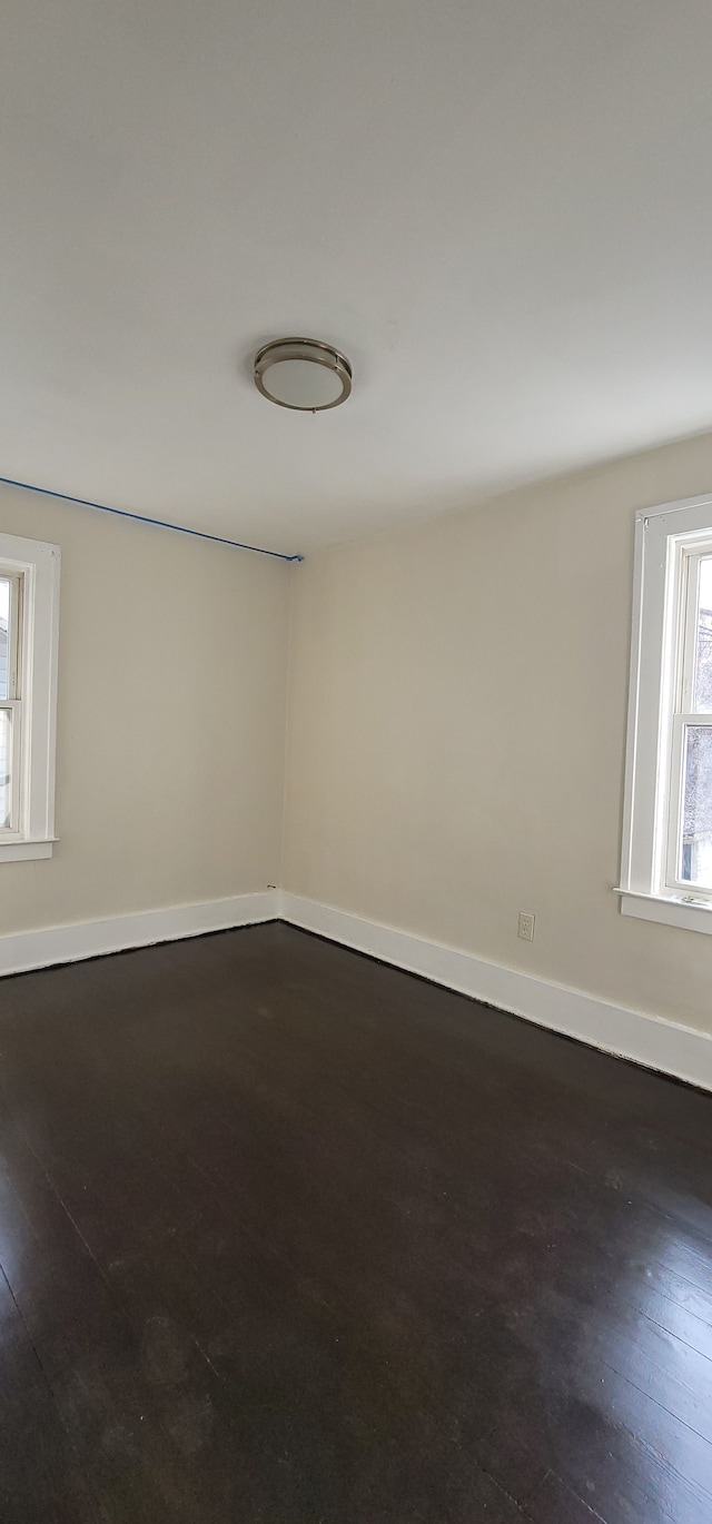 spare room with dark hardwood / wood-style floors