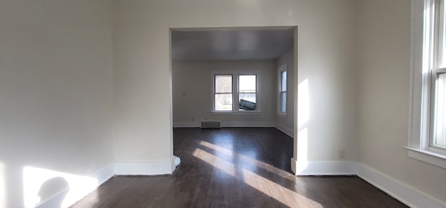 unfurnished room with dark hardwood / wood-style flooring