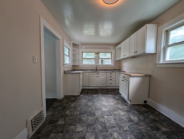 kitchen featuring sink and white cabinets