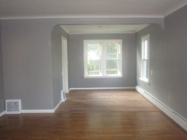 spare room with wood-type flooring and plenty of natural light