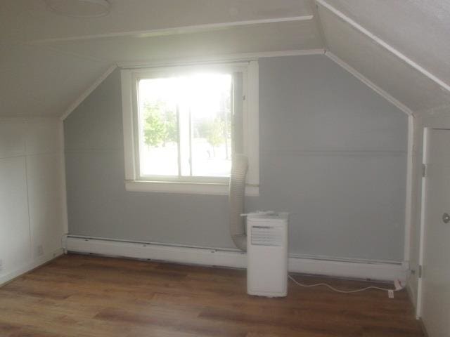 bonus room with wood-type flooring, baseboard heating, and vaulted ceiling