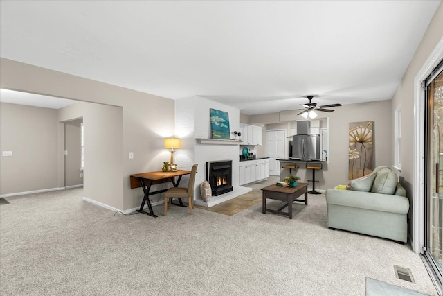 living room featuring light carpet and ceiling fan