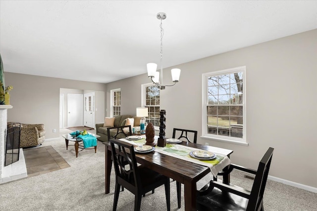 dining space with carpet and a notable chandelier