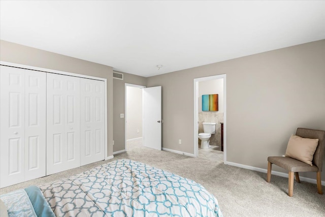 carpeted bedroom featuring ensuite bath and a closet