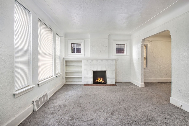 15766 Snowden St, Detroit, MI 48227 - unfurnished living room featuring a textured wall, carpet floors, plenty of natural light, arched walkways, and a textured ceiling