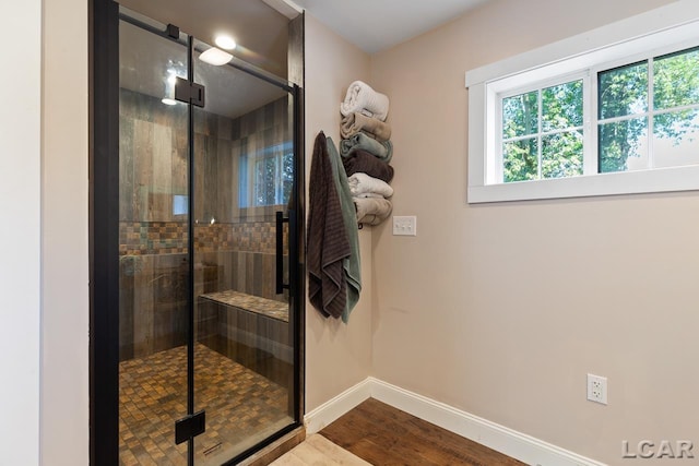 bathroom featuring wood-type flooring and a shower with shower door