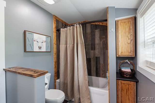 bathroom with shower / bath combo, vaulted ceiling, and toilet