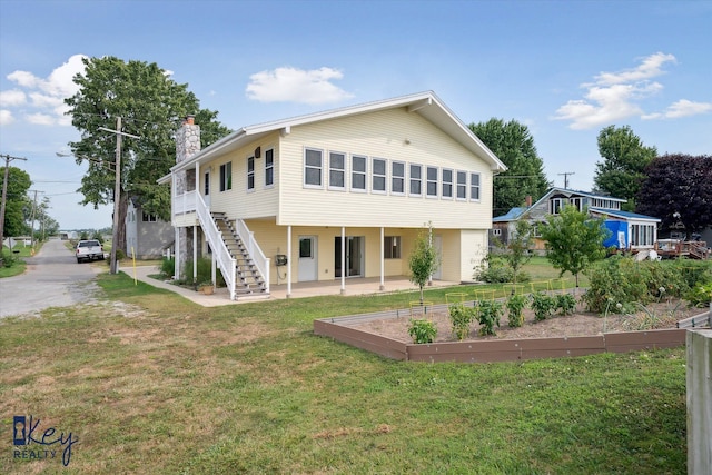 6800 Lakeshore Dr, Newport, MI 48166 - rear view of house with a garden, a lawn, a chimney, a patio, and stairway