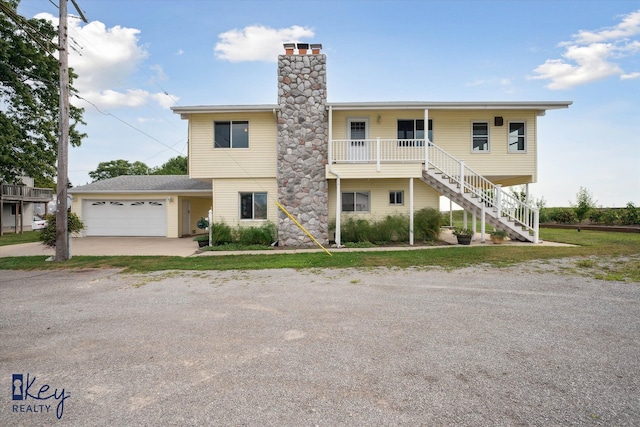 6800 Lakeshore Dr, Newport, MI 48166 - view of front of house featuring a chimney, a garage, driveway, and stairway