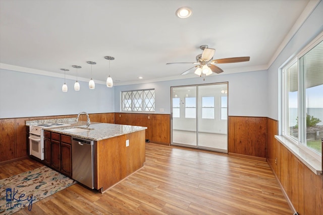 kitchen featuring pendant lighting, dishwasher, white range with electric cooktop, sink, and light hardwood / wood-style floors