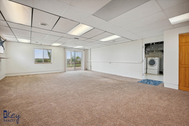 carpeted empty room with separate washer and dryer and a drop ceiling