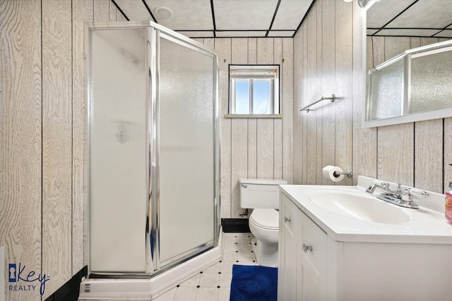 bathroom with vanity, toilet, an enclosed shower, and wooden walls