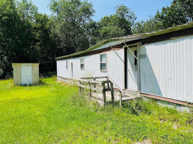 rear view of property with a storage shed