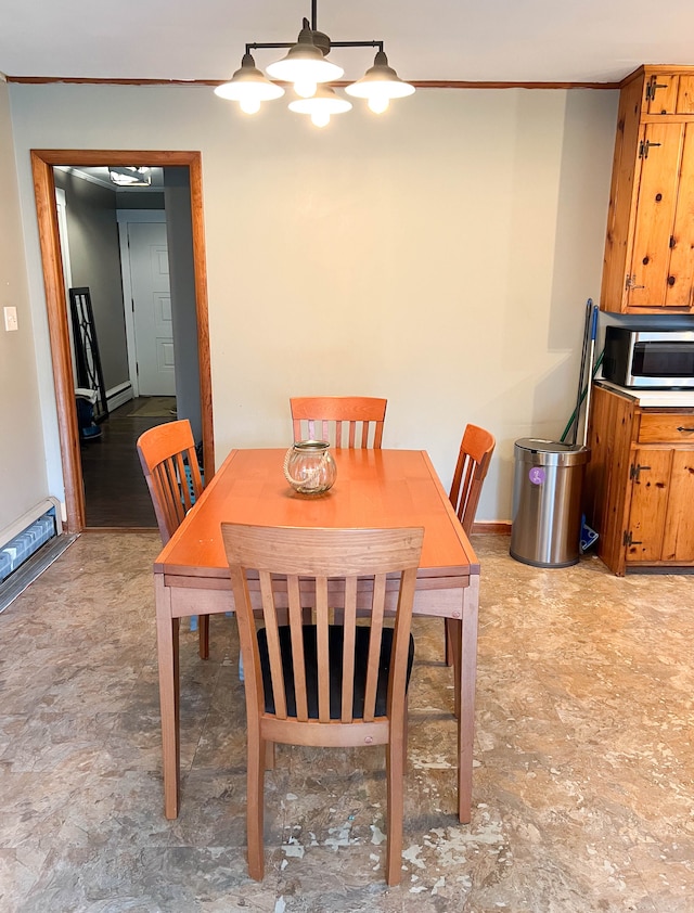 dining room with a baseboard heating unit, crown molding, and a chandelier