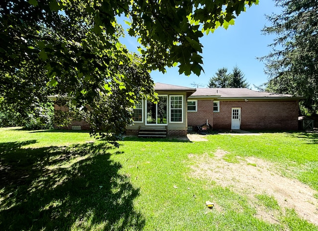 rear view of house featuring a lawn