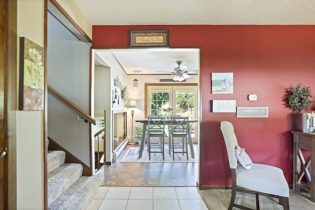 dining area featuring ceiling fan, light tile patterned floors, a textured ceiling, and a baseboard heating unit