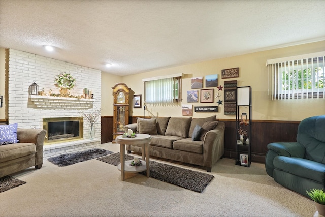 living room featuring carpet flooring, a fireplace, wood walls, and a textured ceiling