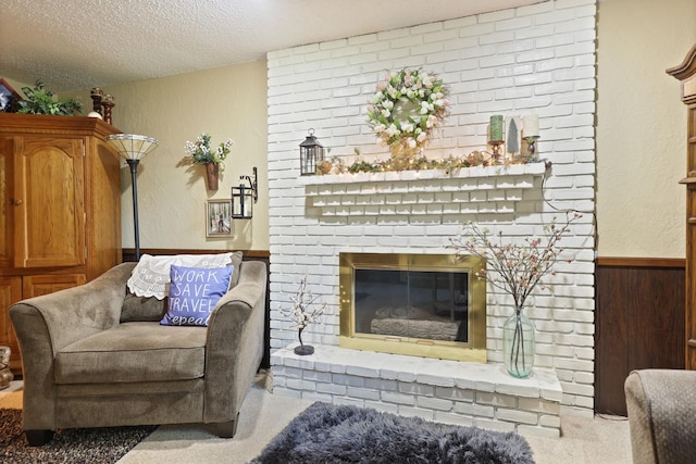 living area featuring a textured ceiling, carpet floors, a brick fireplace, and wood walls