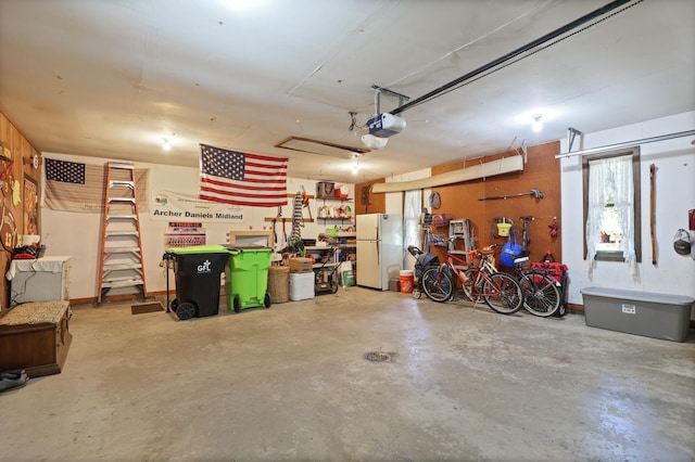 garage with a garage door opener and white refrigerator