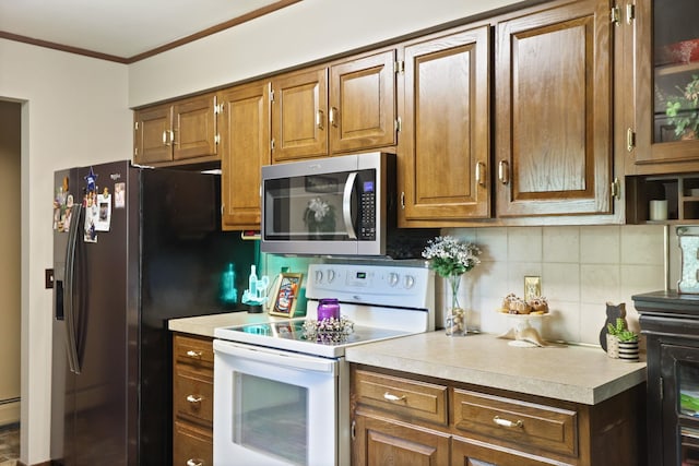 kitchen featuring appliances with stainless steel finishes, backsplash, baseboard heating, and ornamental molding