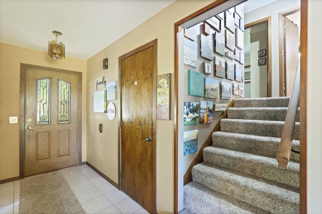 entrance foyer featuring light tile patterned floors and a textured ceiling