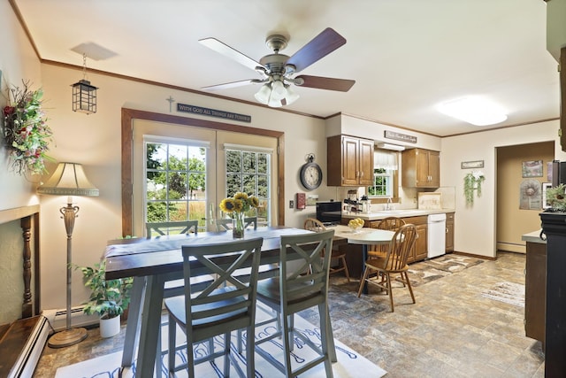 dining room with ceiling fan, baseboard heating, crown molding, and sink