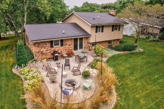 back of property featuring a fire pit, a patio area, and a yard