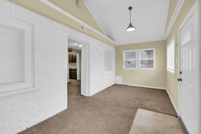 interior space featuring brick wall and lofted ceiling