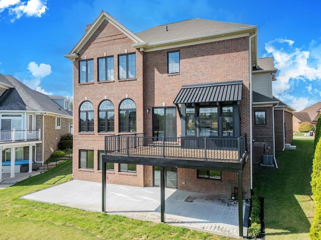 rear view of property featuring a patio, a deck, and a lawn