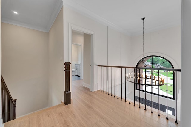 hallway featuring light wood-type flooring, crown molding, and a chandelier