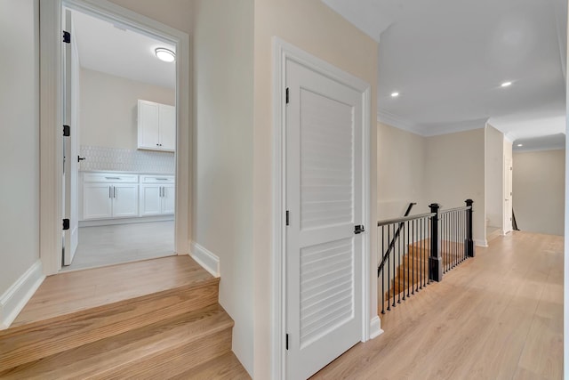 hall featuring crown molding and light hardwood / wood-style flooring