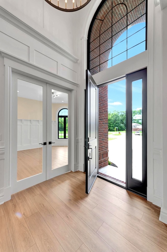 foyer featuring a high ceiling, light hardwood / wood-style flooring, and french doors