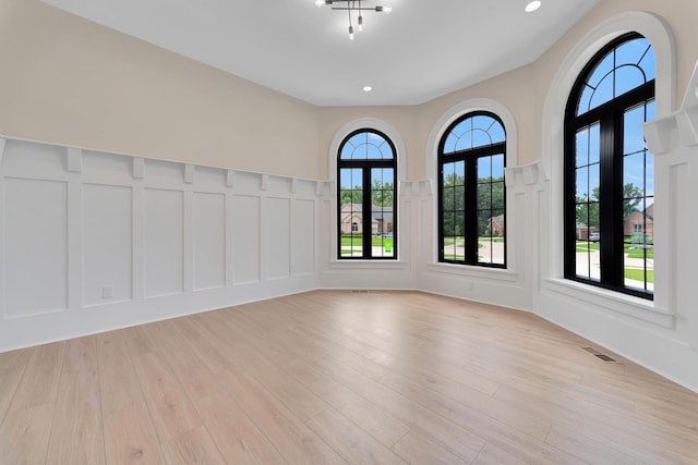 spare room featuring french doors and light wood-type flooring