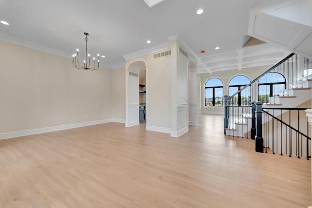 unfurnished living room with beam ceiling, coffered ceiling, an inviting chandelier, crown molding, and light wood-type flooring