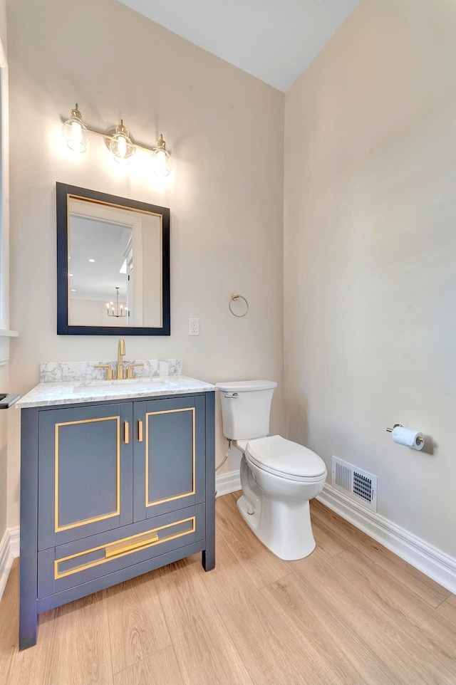 bathroom featuring hardwood / wood-style floors, vanity, and toilet