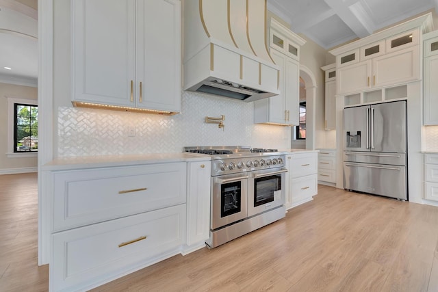 kitchen featuring backsplash, light hardwood / wood-style flooring, and high end appliances