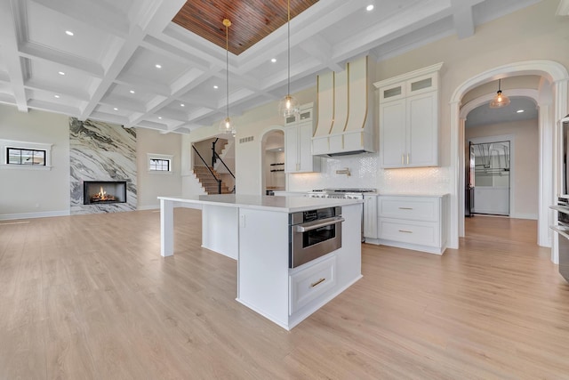 kitchen featuring a kitchen island, light wood-type flooring, and white cabinetry