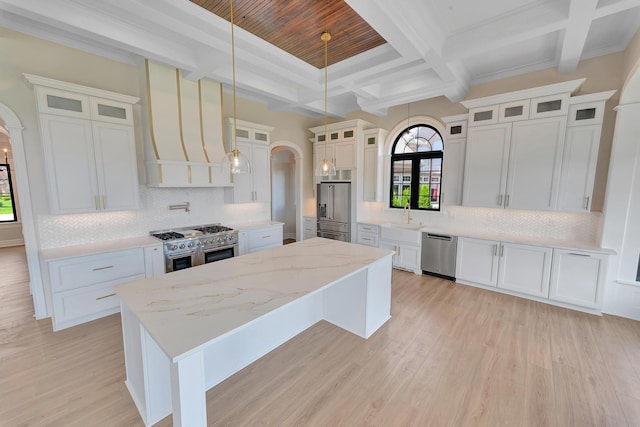 kitchen with decorative backsplash, white cabinets, a kitchen island, and high end appliances