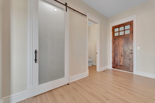 entrance foyer featuring light wood-type flooring and a barn door