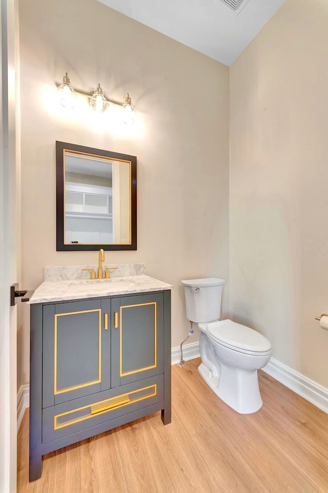 bathroom featuring vanity, wood-type flooring, and toilet