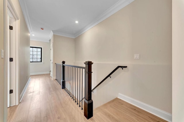 hall with light hardwood / wood-style flooring and crown molding