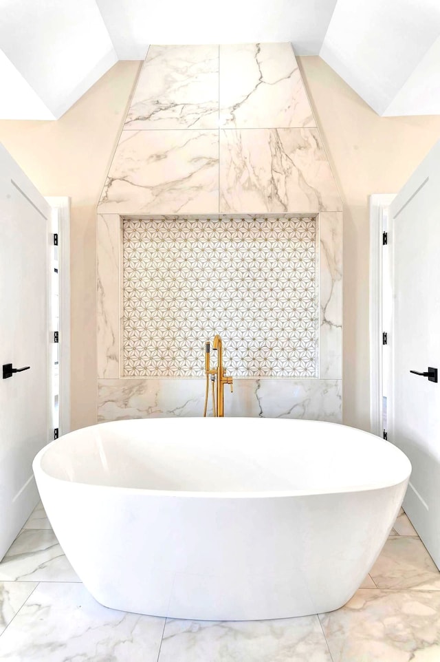 bathroom with vaulted ceiling and a bathing tub