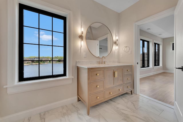 bathroom with hardwood / wood-style floors, vanity, and a water view